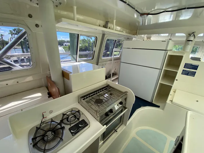 Mirage Yacht Photos Pics Interior of a 1996 Custom 62 yacht kitchen with stove, oven, and refrigerator.