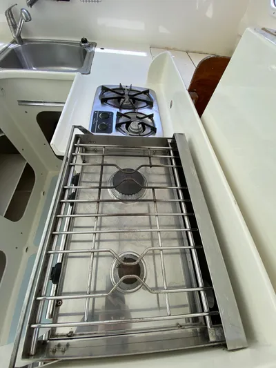 Mirage Yacht Photos Pics Compact kitchen with dual-burner stove and sink, Custom 62 model, 1996.