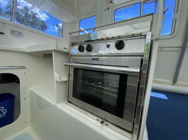 Mirage Yacht Photos Pics Stainless steel oven in a boat's compact kitchen, Custom 62 model, 1996.