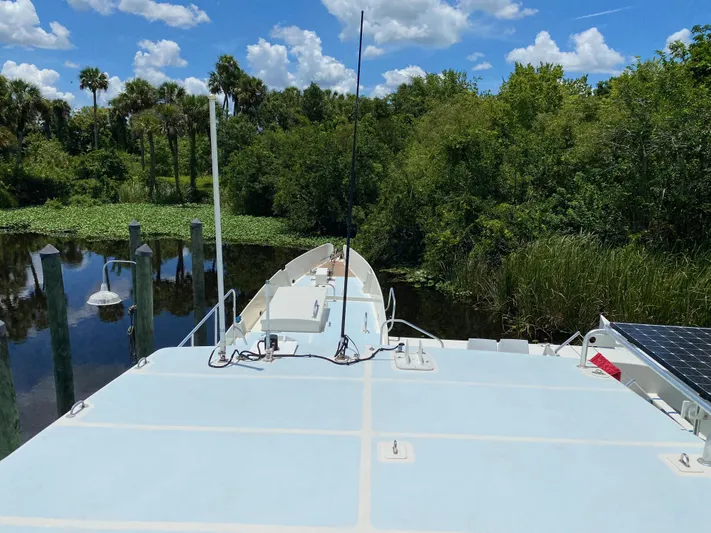 Mirage Yacht Photos Pics Custom 62 boat from 1996 on a serene river with lush greenery.