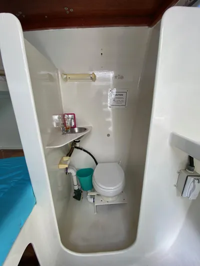 Mirage Yacht Photos Pics Compact marine bathroom with toilet, sink, and storage in a 1996 Custom model 62 boat.