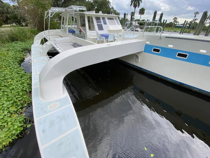 Mirage Yacht Photos Pics Custom 62 catamaran from 1996 docked near lush greenery and calm water.