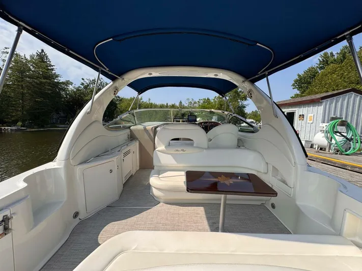 Yacht Photos Pics 2002 Sea Ray 360 Sundancer interior with blue canopy, docked by a serene lakeside.