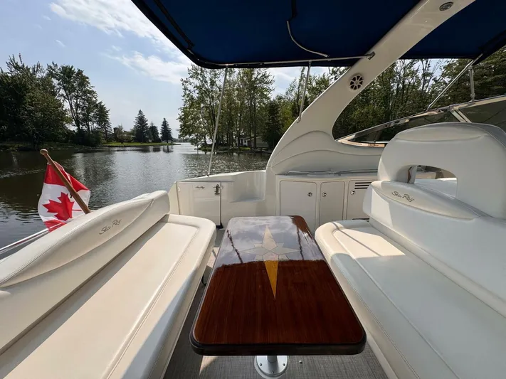  Yacht Photos Pics 2002 Sea Ray 360 Sundancer boat interior with Canadian flag, docked on a serene lake.