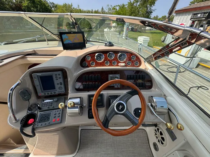  Yacht Photos Pics Helm of 2002 Sea Ray 360 Sundancer with navigation equipment and wooden steering wheel.