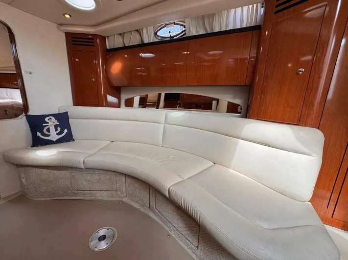  Yacht Photos Pics Luxurious interior of 2002 Sea Ray 360 Sundancer with curved seating and wooden cabinetry.
