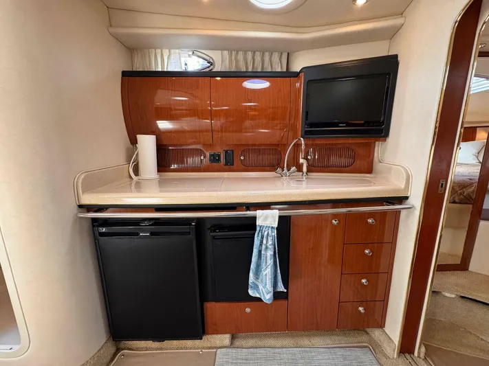  Yacht Photos Pics 2002 Sea Ray 360 Sundancer yacht kitchen with wood cabinetry, sink, and TV.