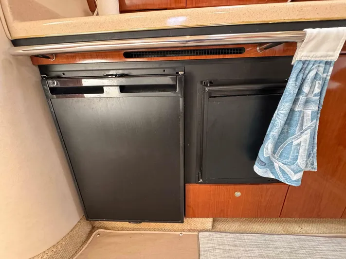  Yacht Photos Pics 2002 Sea Ray 360 Sundancer galley with black appliances and wooden cabinetry.