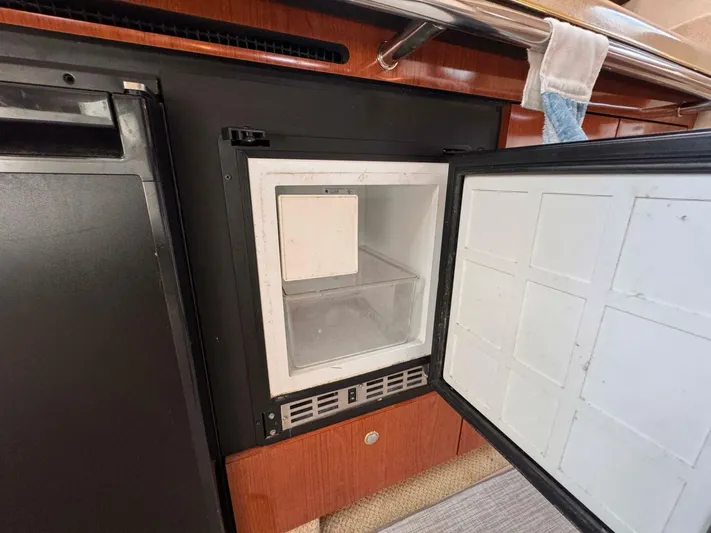  Yacht Photos Pics Open refrigerator on 2002 Sea Ray 360 Sundancer yacht, showcasing interior storage space.