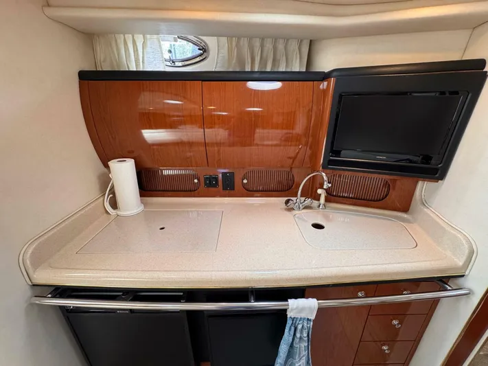  Yacht Photos Pics 2002 Sea Ray 360 Sundancer galley with sink, TV, and storage cabinets.