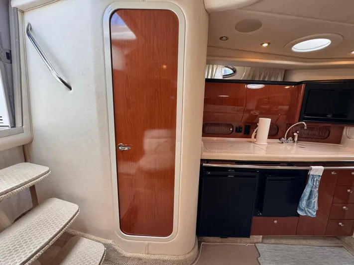  Yacht Photos Pics 2002 Sea Ray 360 Sundancer interior with kitchenette, wooden cabinetry, and compact stairs.