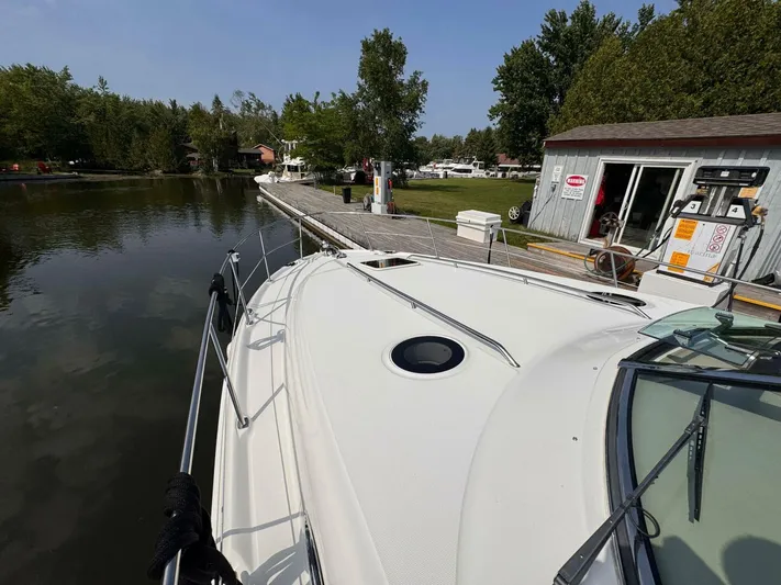  Yacht Photos Pics 2002 Sea Ray 360 Sundancer docked at a marina with lush greenery.