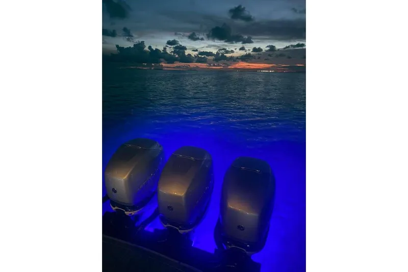  Yacht Photos Pics 2022 Formula 350 Crossover Bowrider OB engines illuminated at sunset over the ocean.