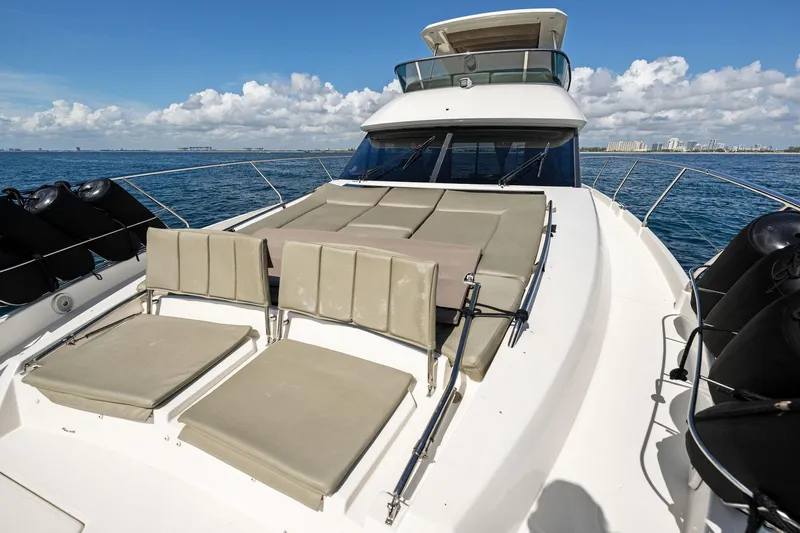 La Peque Yacht Photos Pics Prestige 620 yacht 2016 model with sun loungers on deck, cruising on open water.