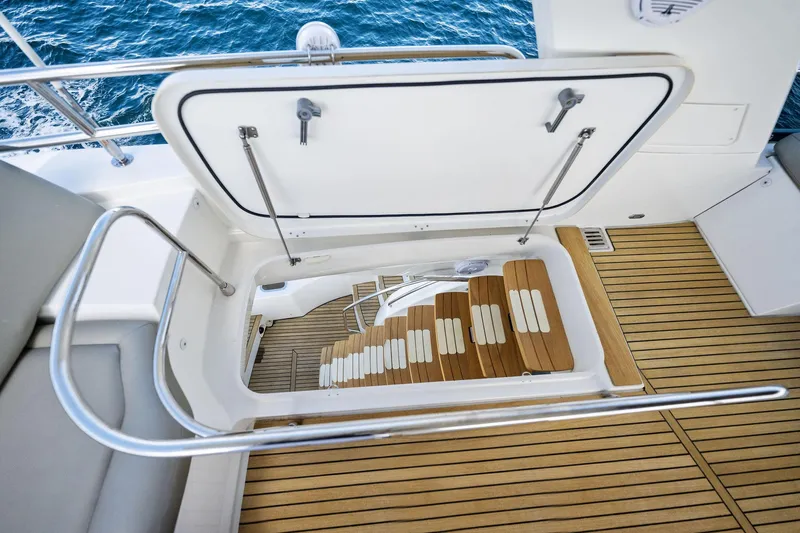La Peque Yacht Photos Pics Open hatch and stairs on 2016 Prestige 620 yacht with teak flooring.