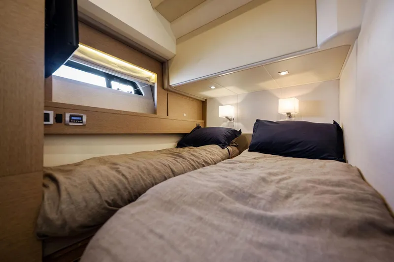 La Peque Yacht Photos Pics Prestige 620 2016 yacht cabin with twin beds, modern lighting, and window view.