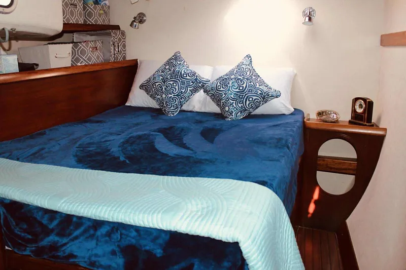 Destiny 2 Yacht Photos Pics Cozy cabin interior of 2000 Fountaine Pajot Belize 43 with blue bedding and decorative pillows.