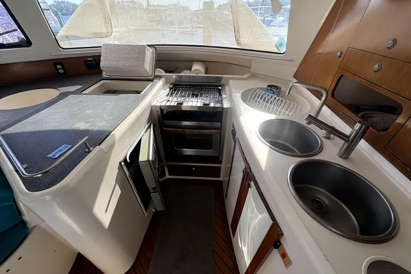 Destiny 2 Yacht Photos Pics Compact kitchen area in a 2000 Fountaine Pajot Belize 43 catamaran, featuring dual sinks and stove.
