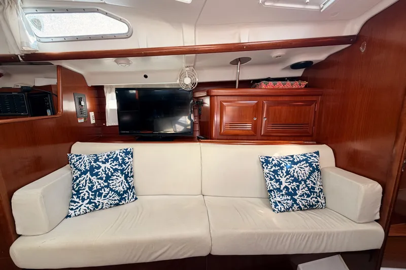 Parlay Yacht Photos Pics Interior of 2003 Beneteau Oceanis Clipper 473 with white sofa and blue coral pillows.