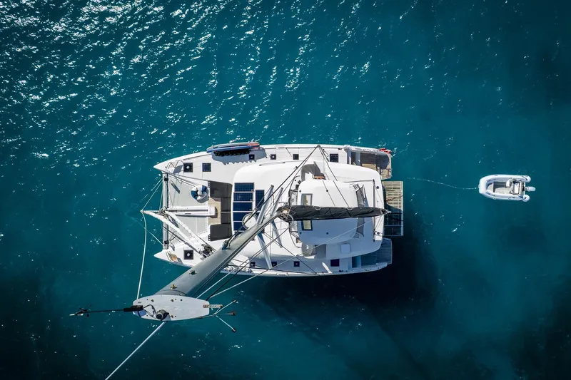 Scuba Doo Yacht Photos Pics Aerial view of 2021 Lagoon 50 catamaran on clear blue water.