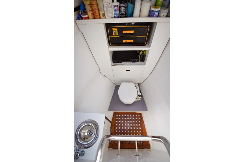 Scuba Doo Yacht Photos Pics Compact bathroom in 2021 Lagoon 50 yacht with toilet, sink, and storage shelves.