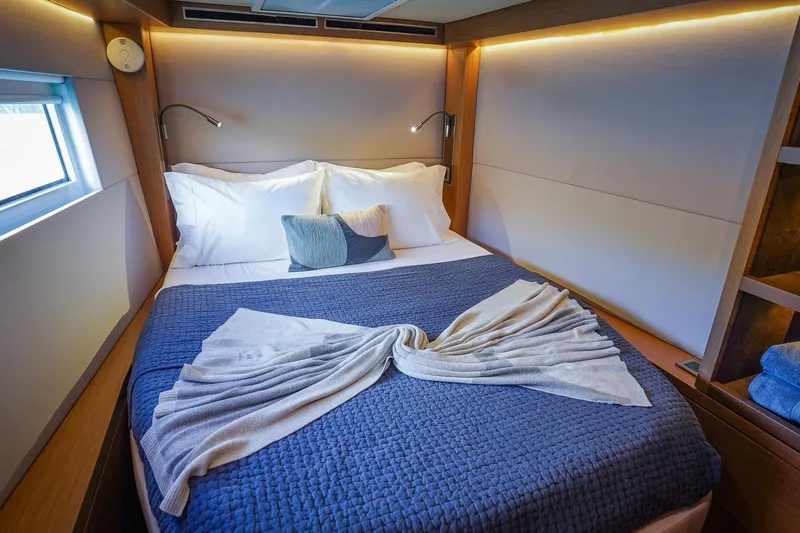 Scuba Doo Yacht Photos Pics Luxurious cabin interior of 2021 Lagoon 50 yacht with cozy bedding and ambient lighting.