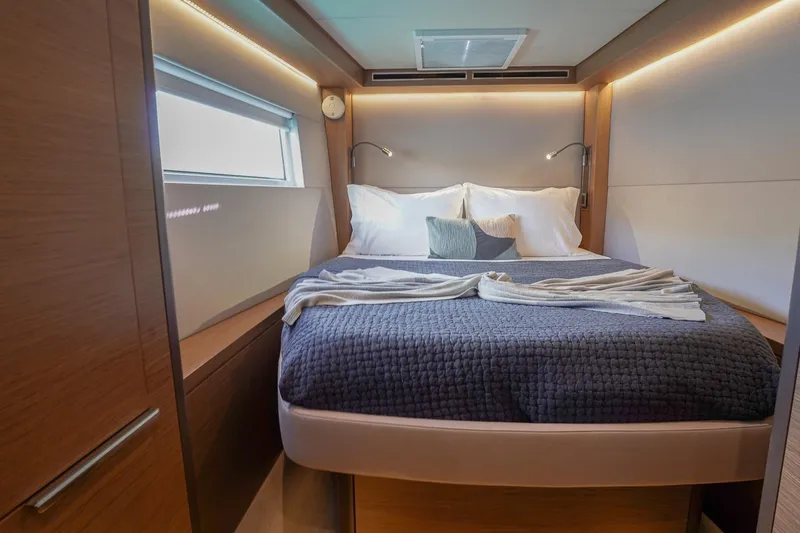Scuba Doo Yacht Photos Pics Luxurious bedroom interior of 2021 Lagoon 50 yacht with modern design and cozy bedding.