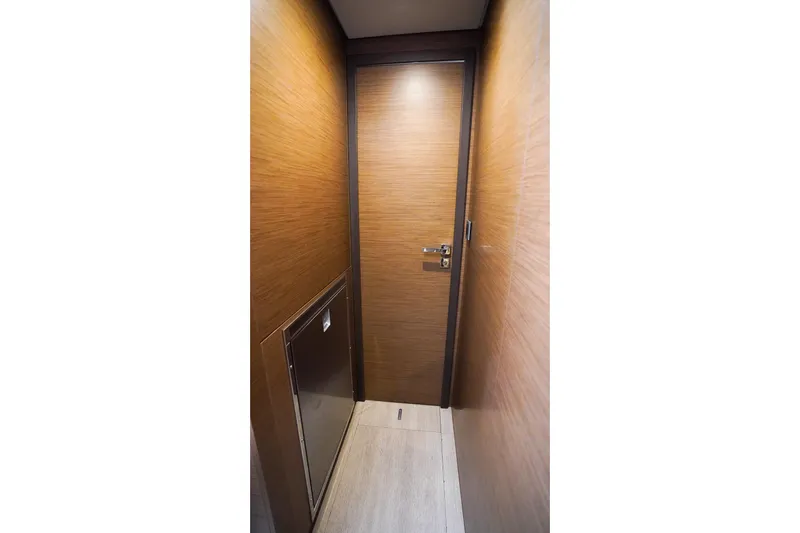 Scuba Doo Yacht Photos Pics Narrow hallway with wooden walls and door inside 2021 Lagoon 50 yacht.