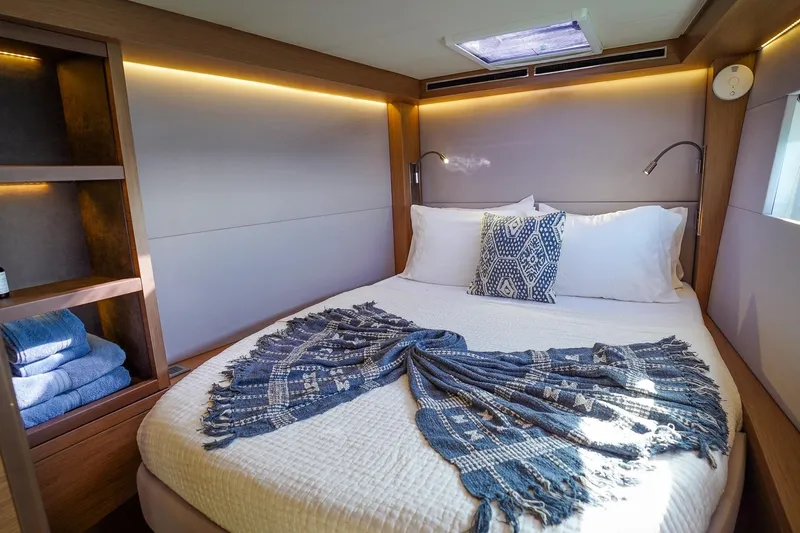 Scuba Doo Yacht Photos Pics Luxurious bedroom interior of 2021 Lagoon 50 yacht with cozy bedding and ambient lighting.
