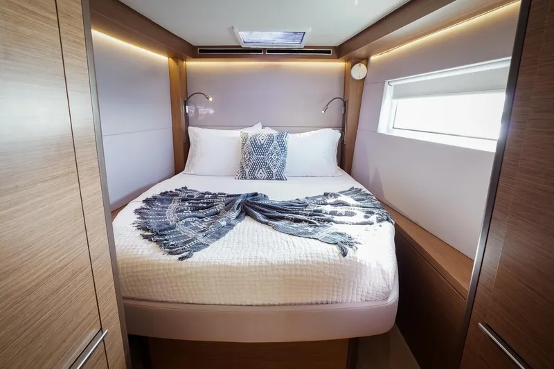 Scuba Doo Yacht Photos Pics Luxurious bedroom interior of 2021 Lagoon 50 yacht with modern design and cozy bedding.