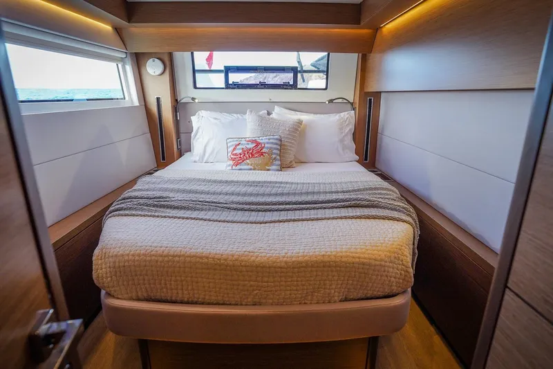 Scuba Doo Yacht Photos Pics Luxurious bedroom interior of 2021 Lagoon 50 yacht with cozy bedding and ocean view.