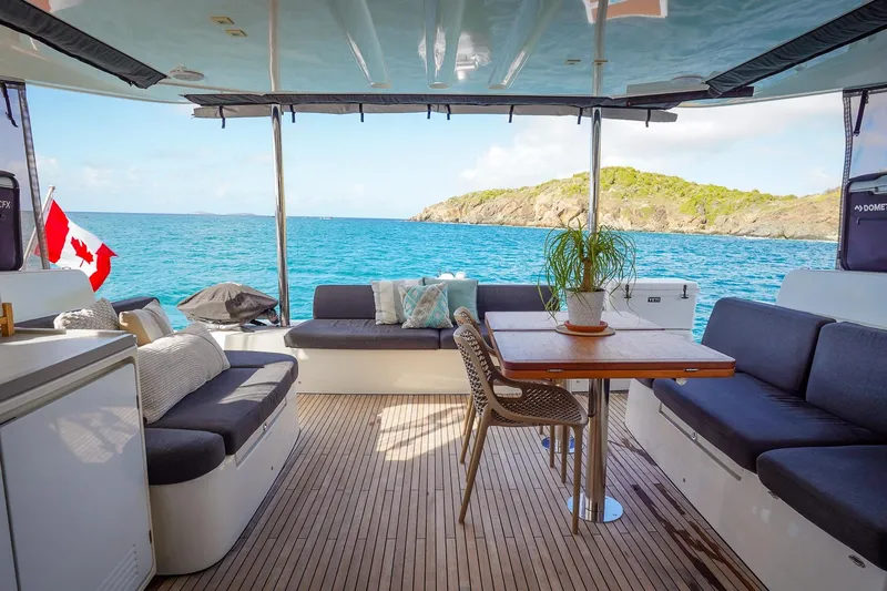 Scuba Doo Yacht Photos Pics Luxurious Lagoon 50 catamaran interior with ocean view, featuring comfortable seating and a dining table.