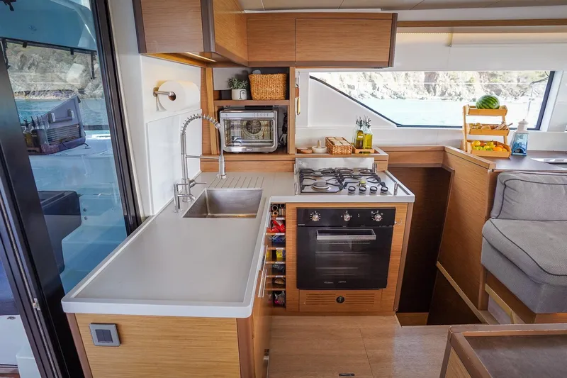 Scuba Doo Yacht Photos Pics Modern kitchen interior of 2021 Lagoon 50 yacht with stove, sink, and scenic window view.