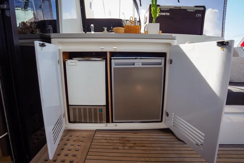 Scuba Doo Yacht Photos Pics Open cabinet on Lagoon 50 yacht, revealing compact fridge and freezer, 2021 model.