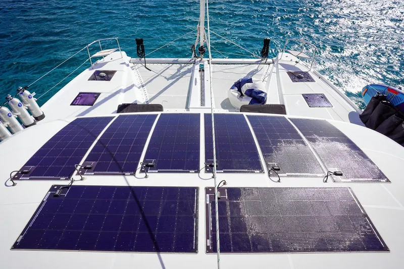 Scuba Doo Yacht Photos Pics 2021 Lagoon 50 catamaran with solar panels on deck, sailing on clear blue water.