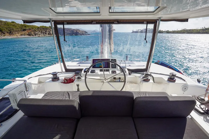 Scuba Doo Yacht Photos Pics Cockpit view of 2021 Lagoon 50 catamaran sailing in clear blue waters.