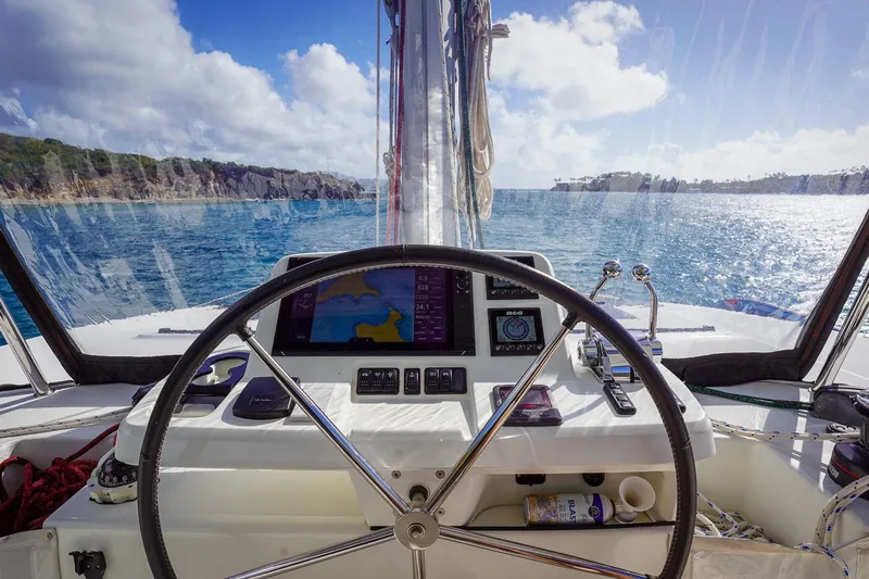 Scuba Doo Yacht Photos Pics Cockpit view of 2021 Lagoon 50 catamaran sailing on a sunny day.
