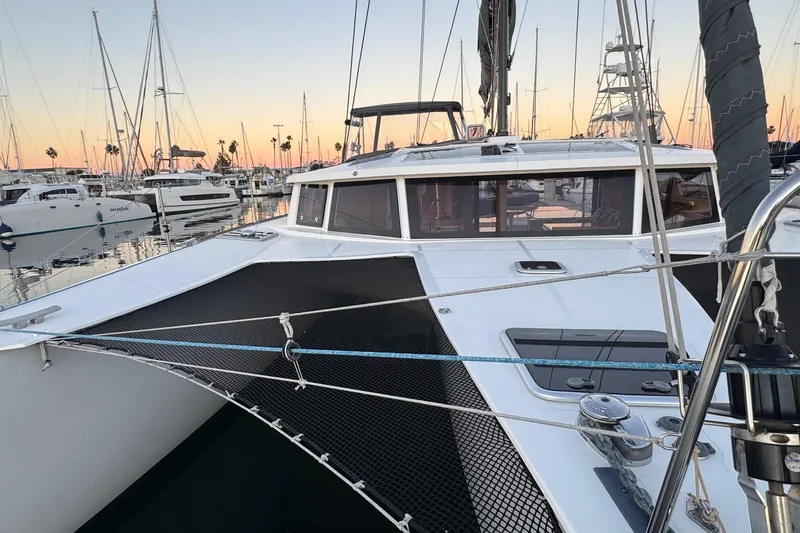 Keizan Yacht Photos Pics 2023 NEEL 43 trimaran docked at marina during sunset, surrounded by sailboats.