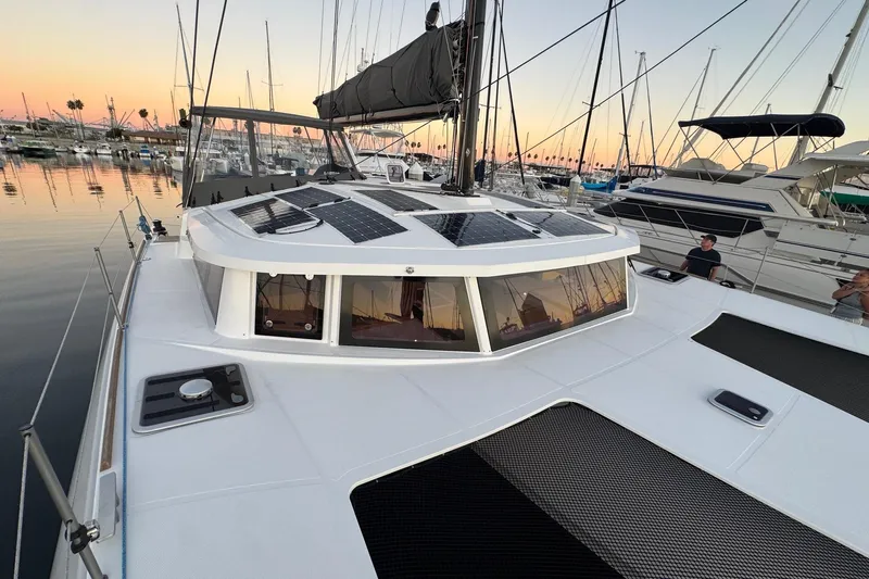 Keizan Yacht Photos Pics Modern NEEL 43 trimaran docked at sunset, featuring solar panels on deck.
