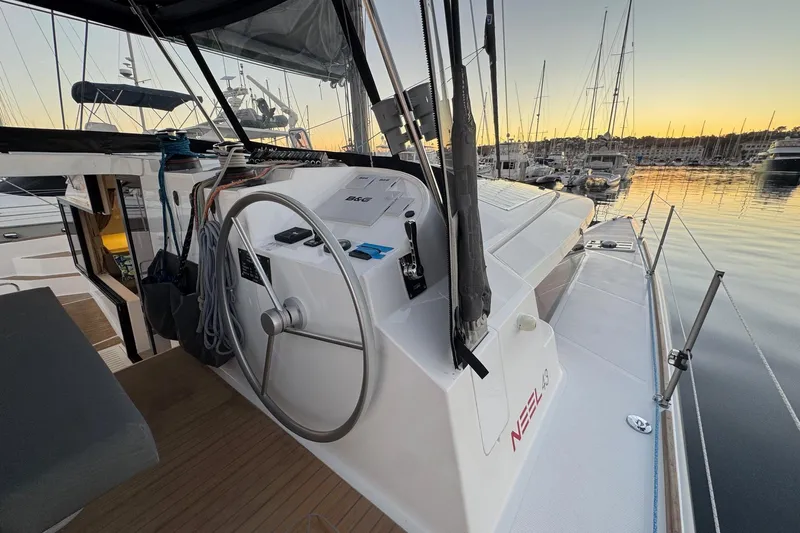 Keizan Yacht Photos Pics Sailing yacht NEEL 43, 2023 model, docked at sunset with steering wheel and deck view.