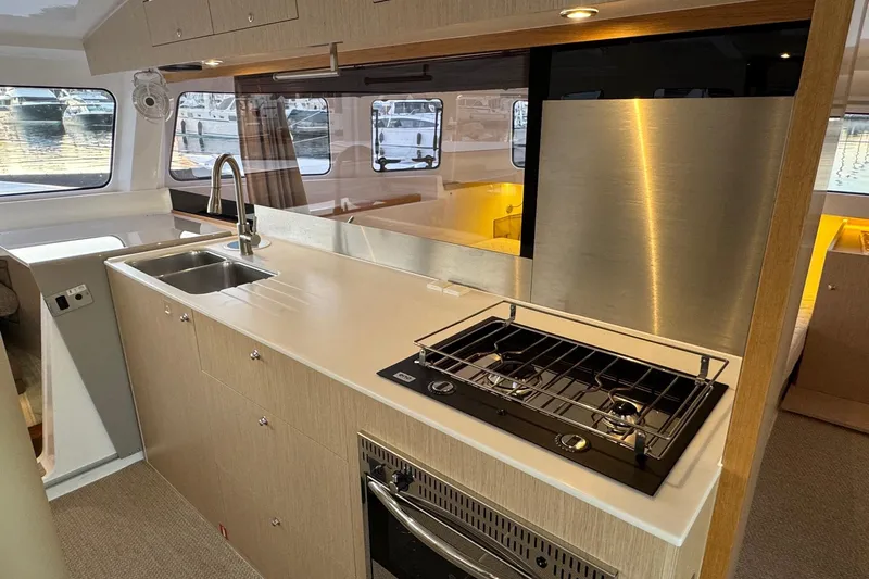 Keizan Yacht Photos Pics Modern kitchen interior on 2023 NEEL 43 yacht with stove, sink, and stainless steel appliances.