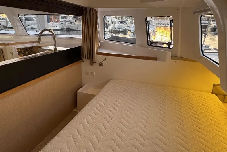 Keizan Yacht Photos Pics Interior of 2023 NEEL 43 yacht with bed and marina view through windows.