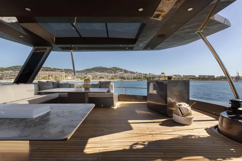  Yacht Photos Pics Luxurious Moon 65 yacht deck with modern seating, overlooking scenic coastal view, 2025 model.