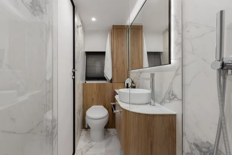  Yacht Photos Pics Modern bathroom with marble walls, wooden accents, and sleek fixtures in a 2025 Moon 65 model.