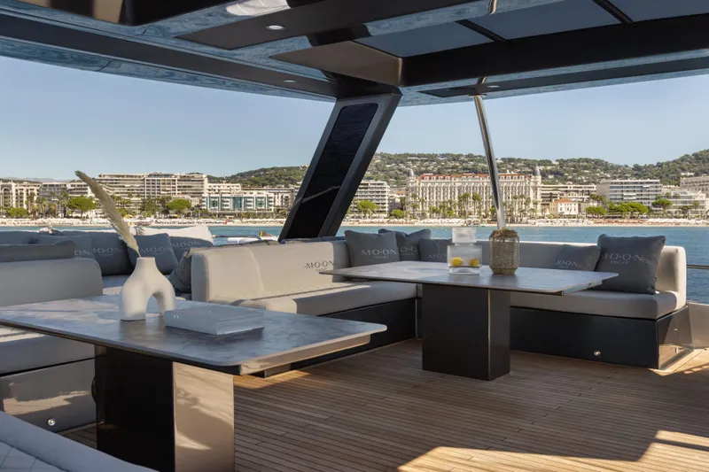  Yacht Photos Pics Luxurious Moon 65 yacht interior with elegant seating, overlooking a scenic coastal city view.