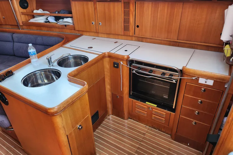 Runaway Yacht Photos Pics 2005 Elan 40 yacht kitchen with dual sinks, oven, and wooden cabinetry.
