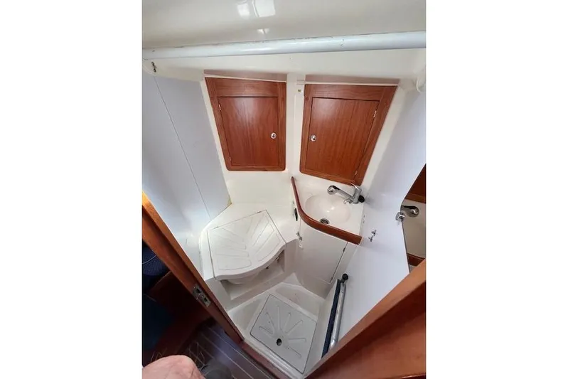 Runaway Yacht Photos Pics Interior of 2005 Elan 40 yacht bathroom with wooden cabinets and compact sink.