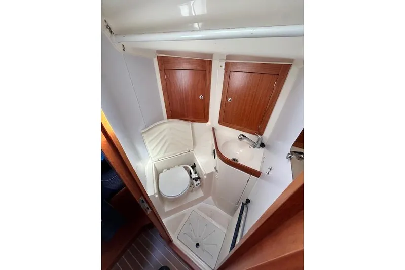 Runaway Yacht Photos Pics Compact bathroom in 2005 Elan 40 yacht with wooden cabinets and white fixtures.