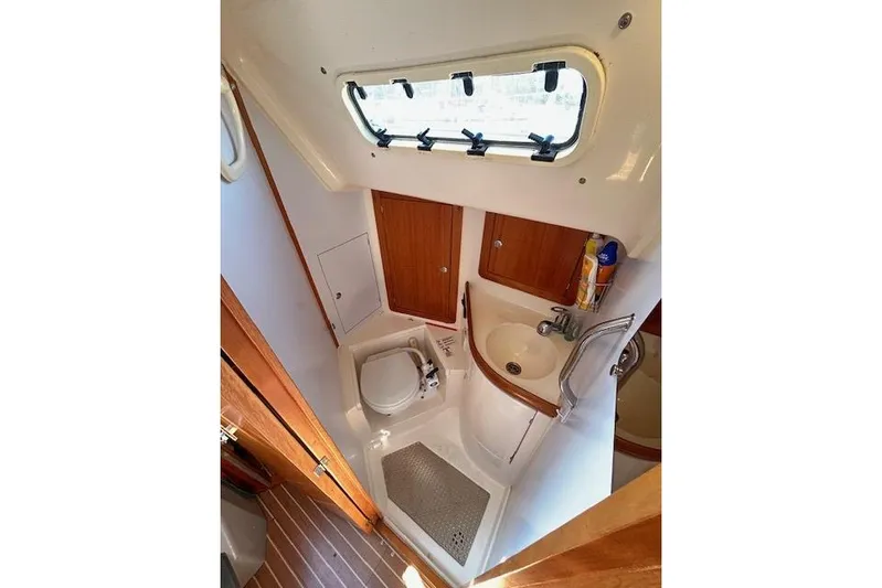Runaway Yacht Photos Pics Compact bathroom in 2005 Elan 40 yacht with toilet, sink, and window.
