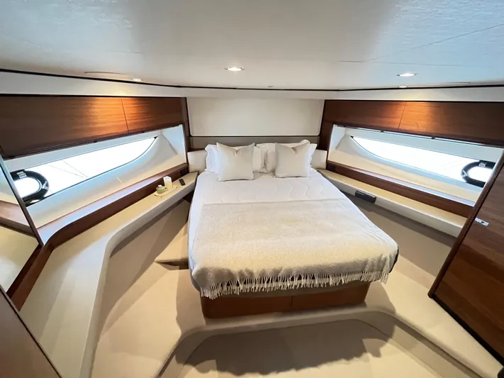 Amussay Yacht Photos Pics Luxurious cabin interior of 2020 Princess F62 yacht with elegant bedding and wood accents.